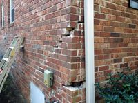 Stair-step cracking in a brick wall on a Metro Atlanta home, the kind of damage that brings homeowners to us asking what a repair costs.